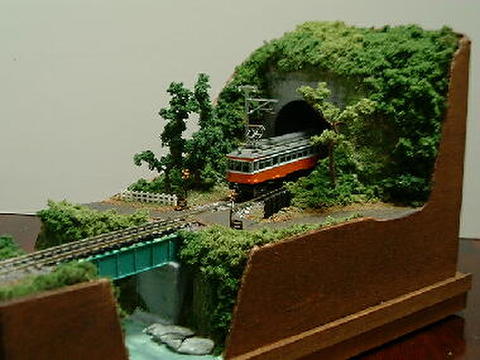 ミニらま３　    小さな踏切に川とトンネルのある鉄道風景