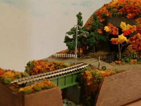 ミニらま３-２　    小さな踏切に川とトンネルのある鉄道風景（紅葉バ－ジョン）